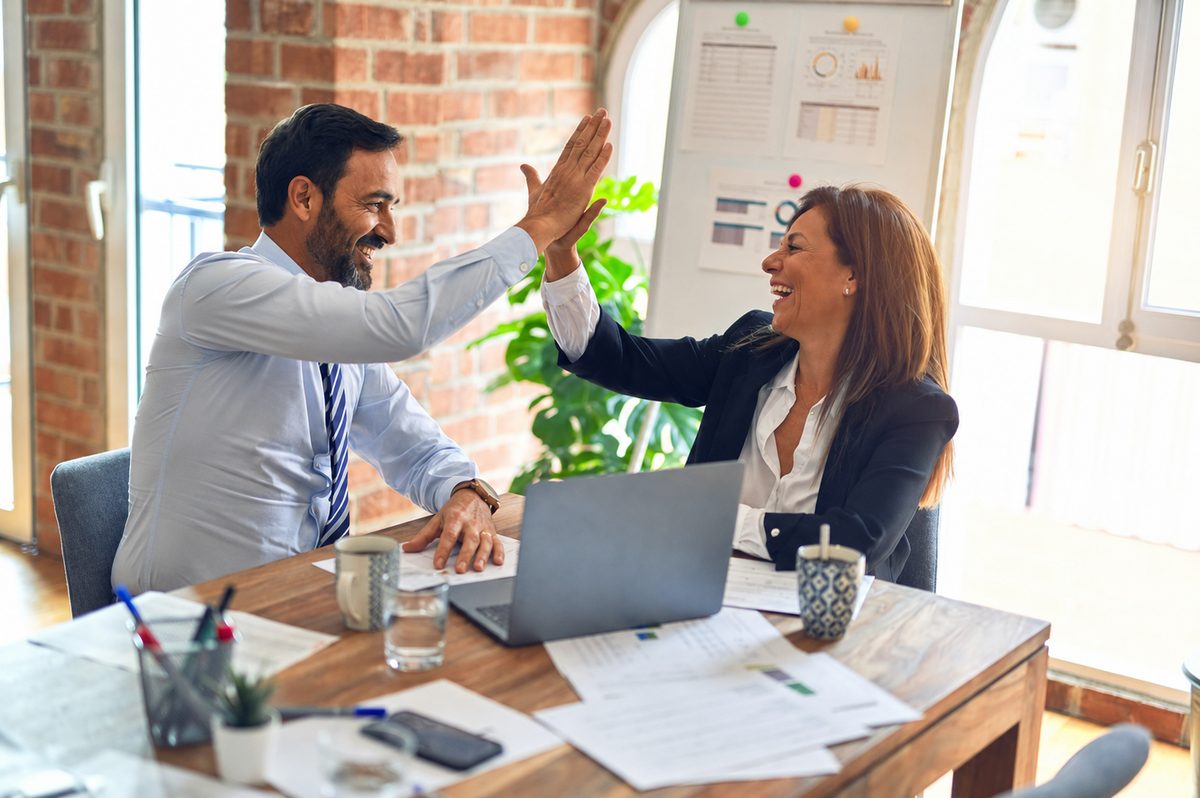Two colleagues high fiving after a successful placement