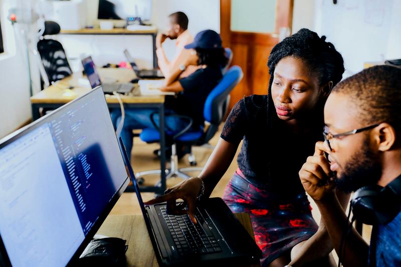 Two colleagues reviewing candidate data on a laptop screen